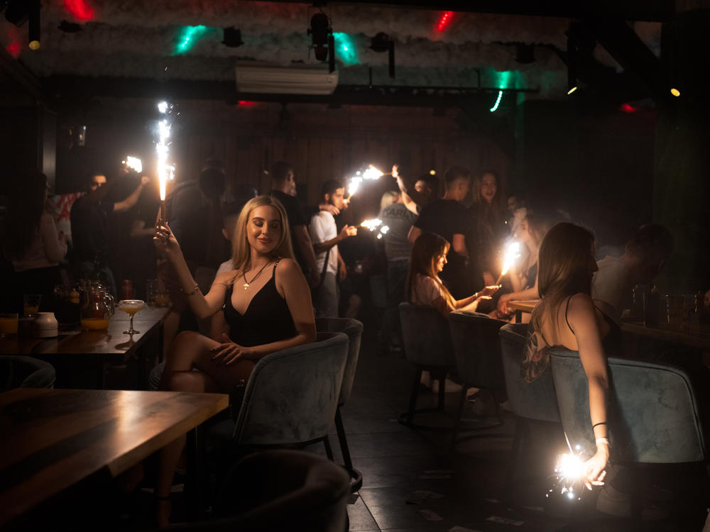 Patrons at a club in Kharkiv hold sparklers in the darkened room in eastern Ukraine. Despite the ongoing war, people are still finding a way release tension in nightclubs in the the battered city.