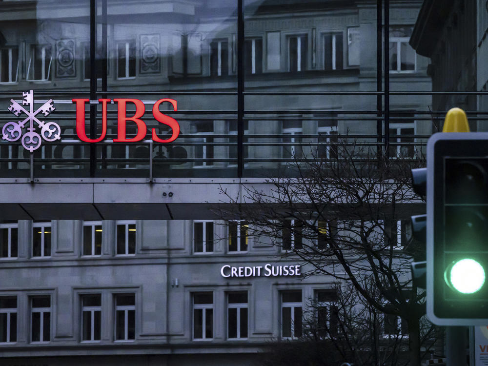 A traffic light signals green in front of the logos of the Swiss banks Credit Suisse and UBS in Zurich, Switzerland, March 19, 2023.