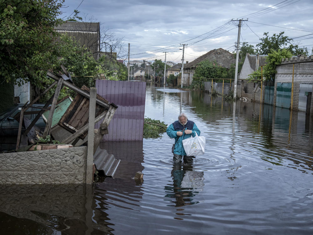 A resident walks on Sunday in a flooded street after the Kakhovka Dam burst and unleashed floodwaters, in Kherson, Ukraine.