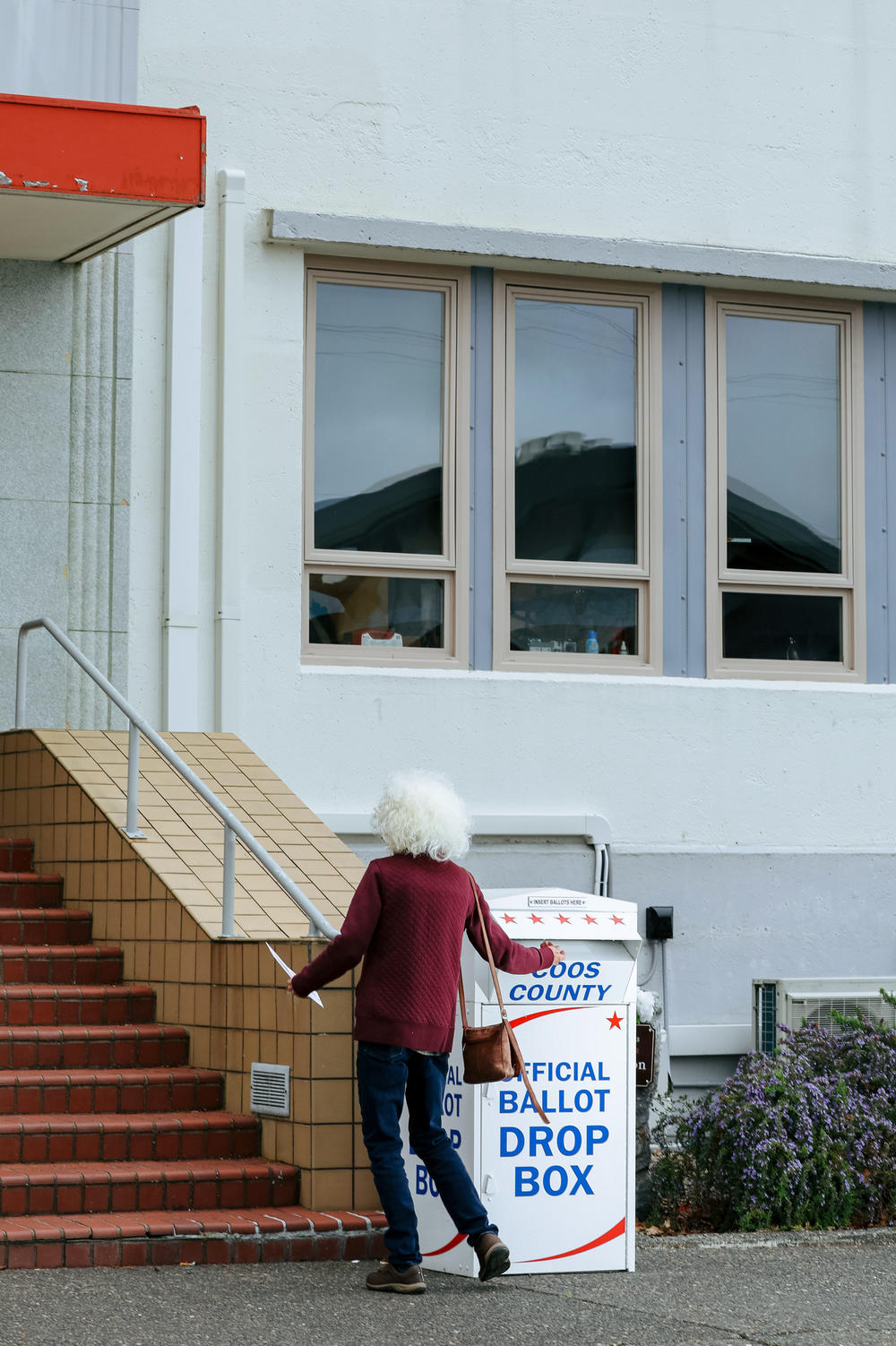 A county resident drops a special election ballot in the box in front of the Coos County Courthouse in Coquille, Ore.