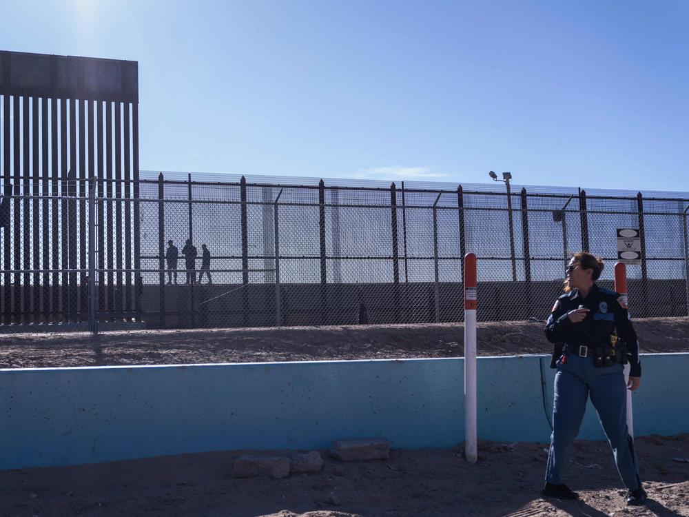 A U.S. law enforcement officer stands guard by a fence along the U.S.-Mexico border at El Paso, Texas.