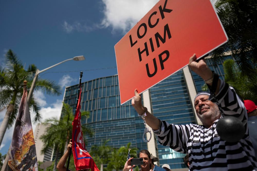 Demonstrators against and supporters of former President Trump gather outside the Wilkie D. Ferguson Jr. United States Federal Courthouse.