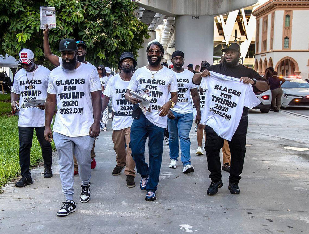 Members of the Blacks for Trump supporter group, lead by Maurice Symonette (center), march in front of the Miami Federal Courthouse.