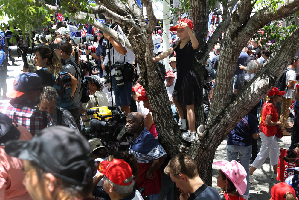 People try to catch a glimpse of former President Trump as he leaves the Wilkie D. Ferguson Jr. federal courthouse.