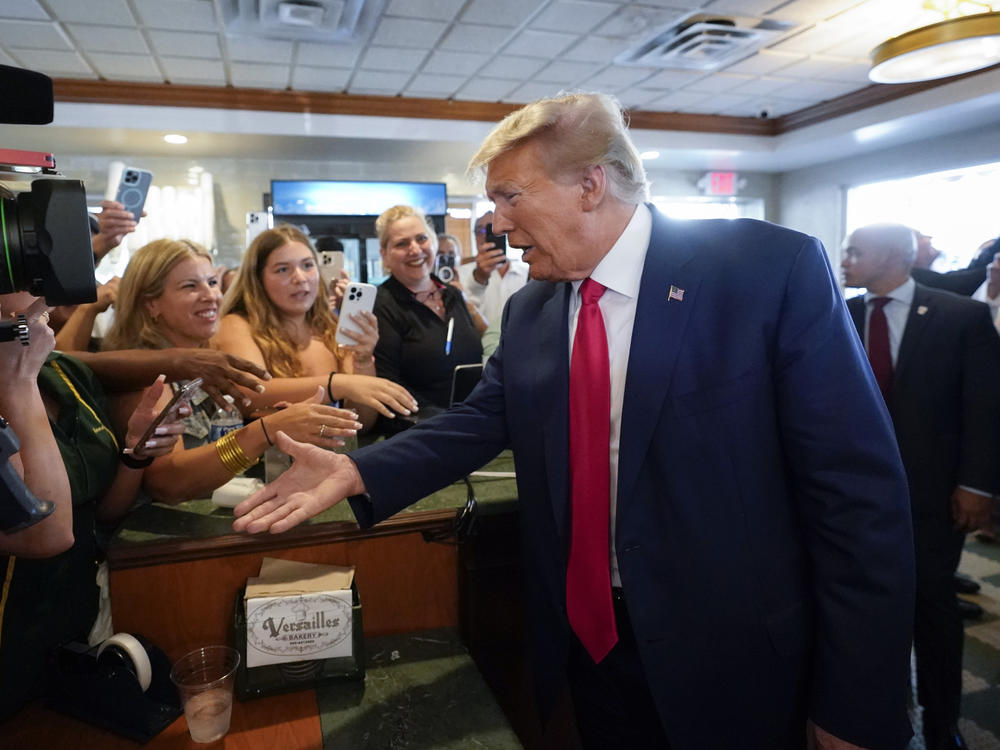 Former President Donald Trump greets supporters as he visits Versailles restaurant on Tuesday in Miami.