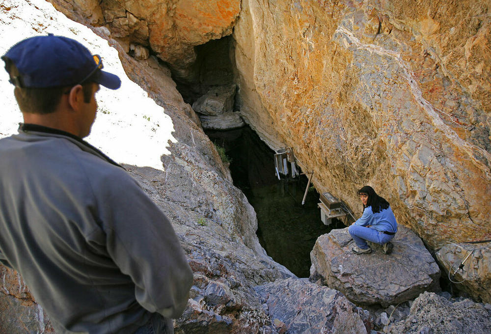 This 2006 photo shows biologist Mike Bower, left, with the National Park Service, and Fish and Wildlife Service field supervisor Cynthia Martinez, as they peer down into Devils Hole.