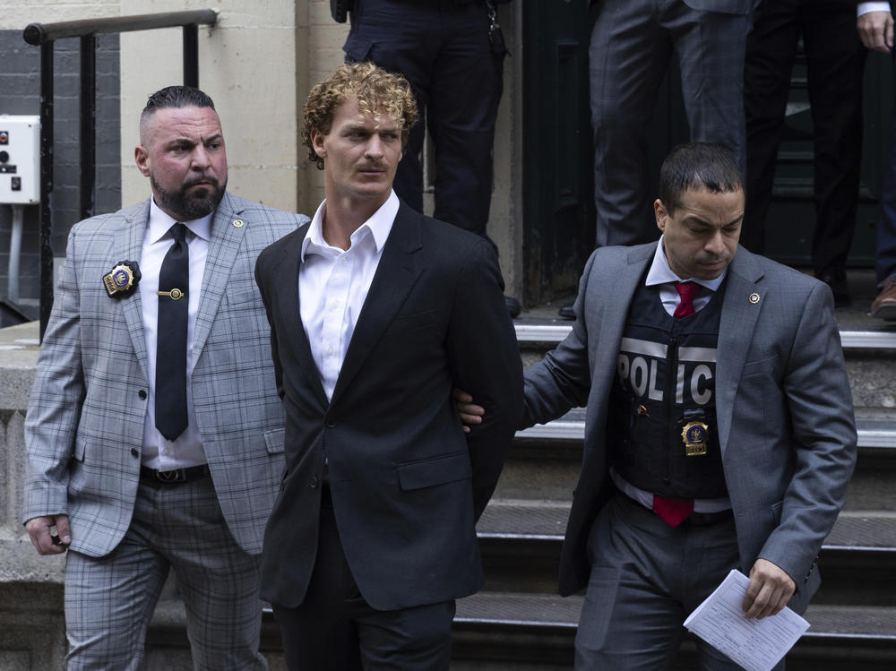 Daniel Penny, center, is walked by New York Police Department detectives out of the 5th Precinct on Wednesday.