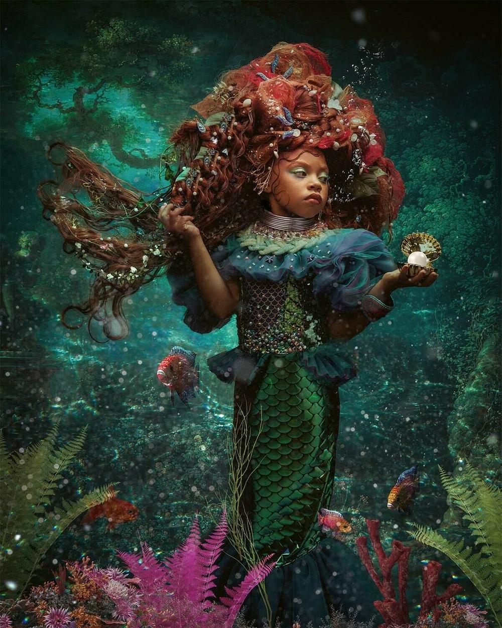 Treasures from the sea nestle in the little mermaid's rosy hair as she strikes a royal pose.