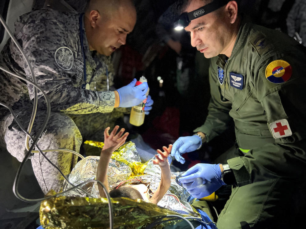 Soldiers of the Colombian Air Force give medical attention inside a plane to the children who survived a Cessna 206 plane crash in the thick jungle, while they are transferred to Bogotá by air in San José del Guaviare, Colombia, June 9.