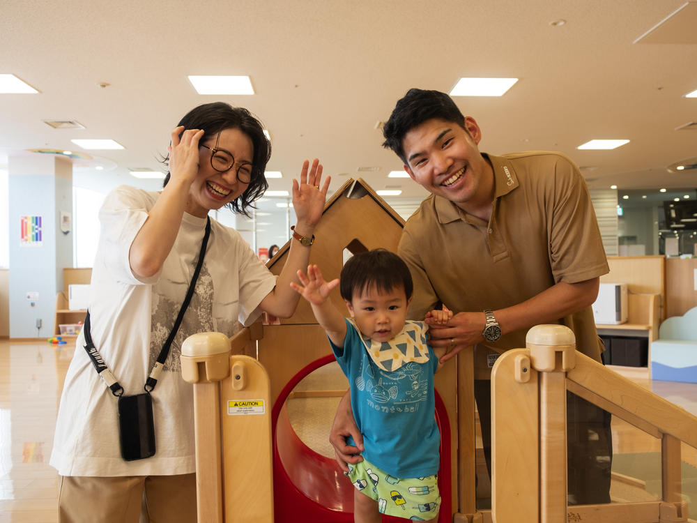 Taiki and Arisa Chisaka watch as their son Tatara plays at a city-run child care center in western Japan's Akashi city.