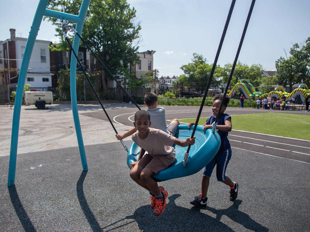 Students play on their new swing in the schoolyard at the Add B. Anderson School. The design features a spongy foundation to help prevent injuries.