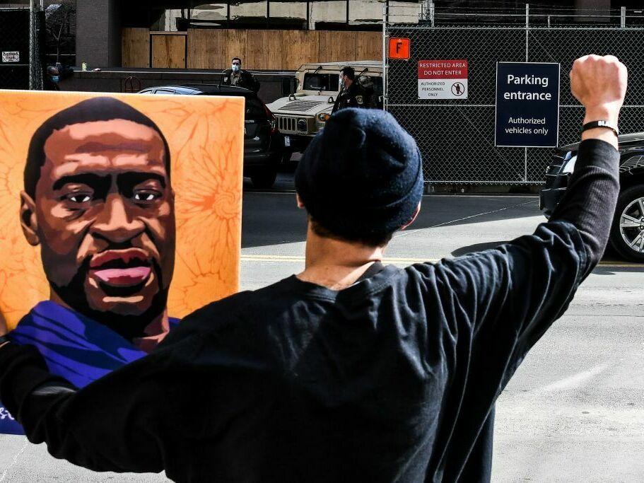 An demonstrator holds a portrait of George Floyd in March 2021 outside the Hennepin County Government in Minneapolis, where the trial of former Minneapolis Police Department officer Derek Chauvin in Floyd's killing was under way.