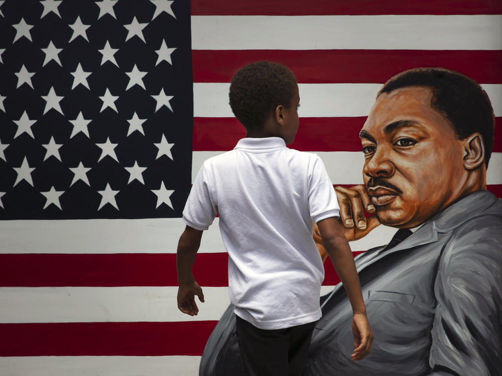 A young boy walks past a painting depicting Dr. Martin Luther King Jr. during a Juneteenth celebration in Los Angeles in 2020. Juneteenth marks the day in 1865 when federal troops arrived in Galveston, Texas, to take control of the state and ensure all enslaved people be freed, more than two years after the Emancipation Proclamation.