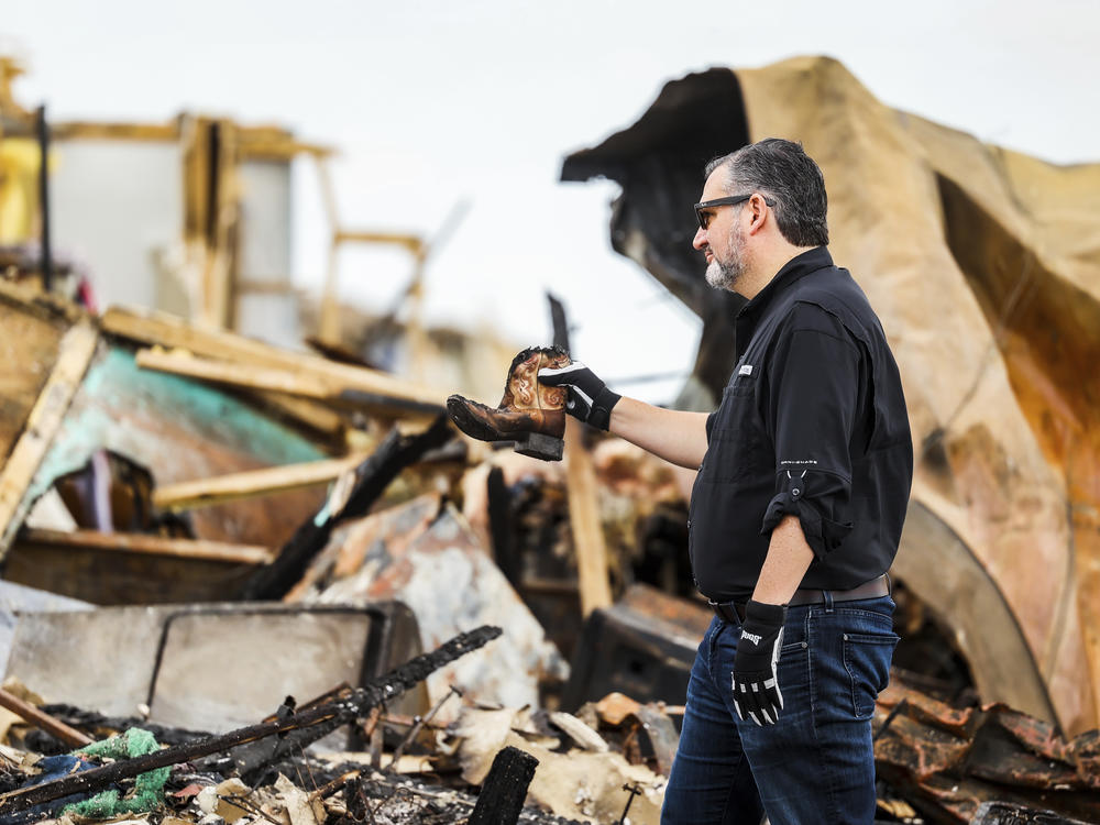 Sen. Ted Cruz, R-Texas, holds up a small cowboy boot he recovered from debris in a trailer park that was damaged by a tornado earlier in Perryton, Texas, Saturday, June, 17, 2023.