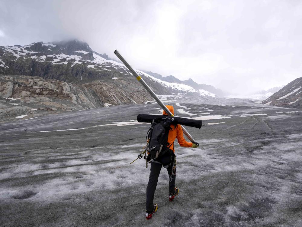 Matthias Huss, a glaciologist and head of the Swiss measurement network 'Glamos', for ETH (the Swiss Federal Institute of Technology) walks up to the Rhone Glacier near Goms, Switzerland, Friday, June 16, 2023.