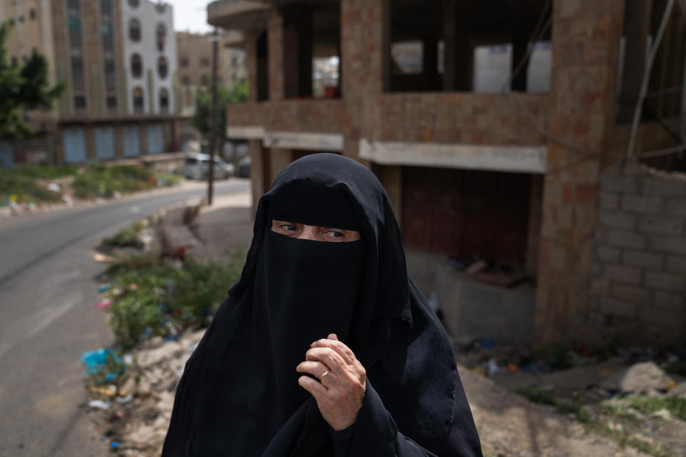 A woman stands near the front lines of the city of Taiz where The internationally recognized government controls one side, and the Houthis control the other.