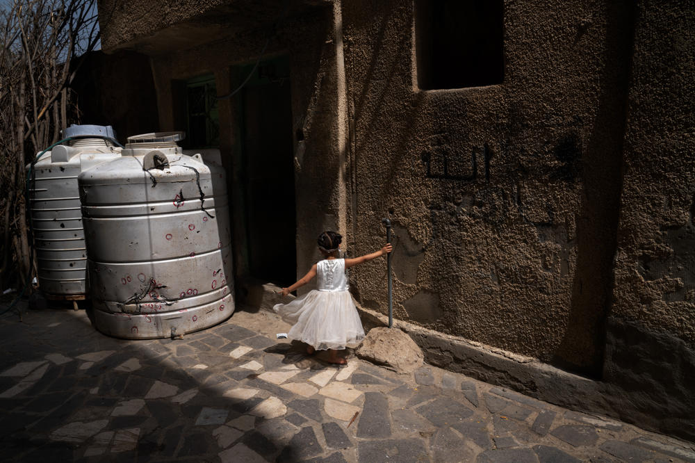 A girl plays near the door to the building where she lives in Al Dawah. Many children have lost their limbs to landmines or been hit by snipers while playing outside.