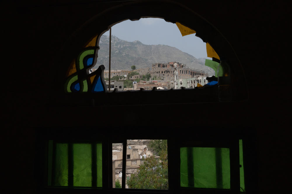 A view of the city of Taiz through a broken stained-glass window in Al Dawah.