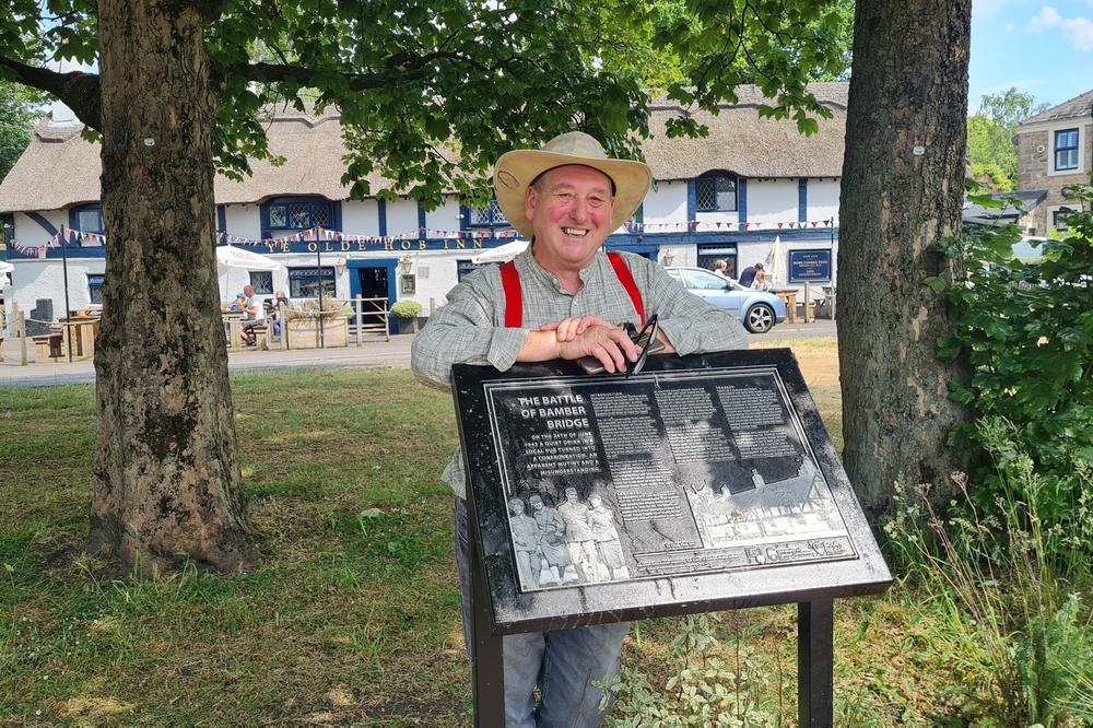 Chris Lomax, mayor of South Ribble, which includes the village of Bamber Bridge, with the plaque he helped install on the village green last year.