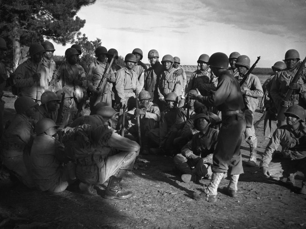 Lt. Frank J. Crawford of Detroit, Michigan, as the Regimental plans and training officer, is giving his men instructions in combat maneuvers.