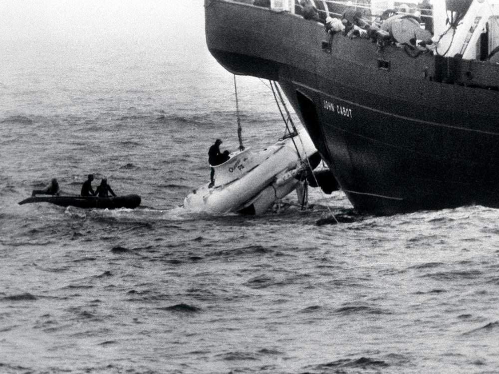Divers begin to open the hatch of Pisces III as she breaks water under the John Cabot after being hauled from the Atlantic seabed off the coast of Cork, Ireland.