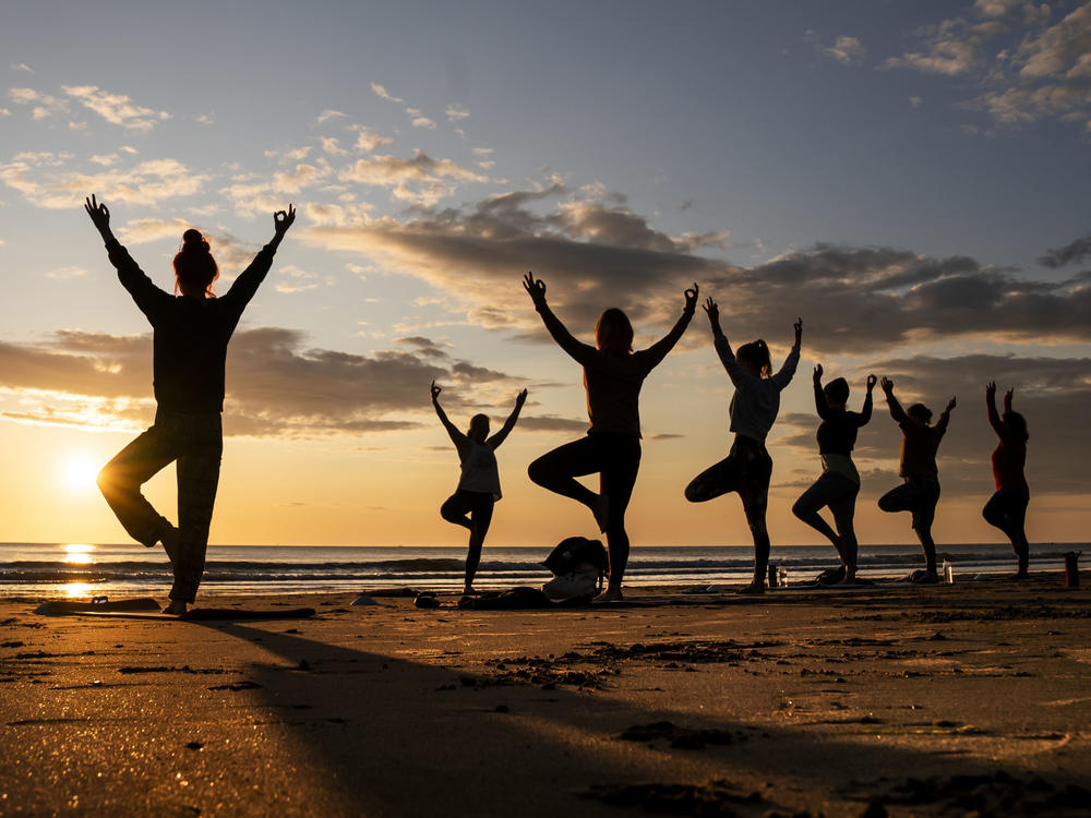Members of the Happy Seal Yoga class practice on Cayton Bay in Scarborough as the sun rises to celebrate the Summer Solstice, Wednesday June 21, 2023.