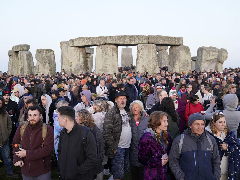 People gather during sunrise as they take part in the Summer Solstice at Stonehenge in Wiltshire, England Wednesday, June 21, 2023.