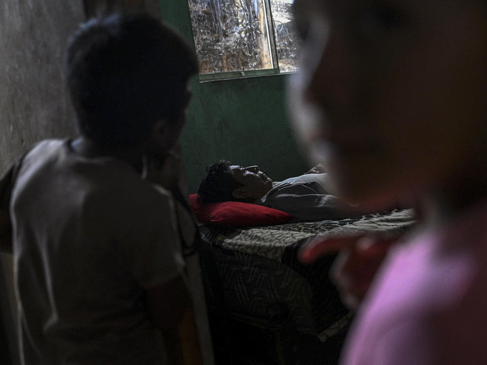 Santos Mendoza (66), who suffers from dengue fever, rests on his bed at his house in the 