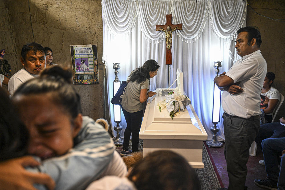 Relatives of 10-year-old Fer Maria Ancajima, who died from dengue fever, mourn during the wake at her house.