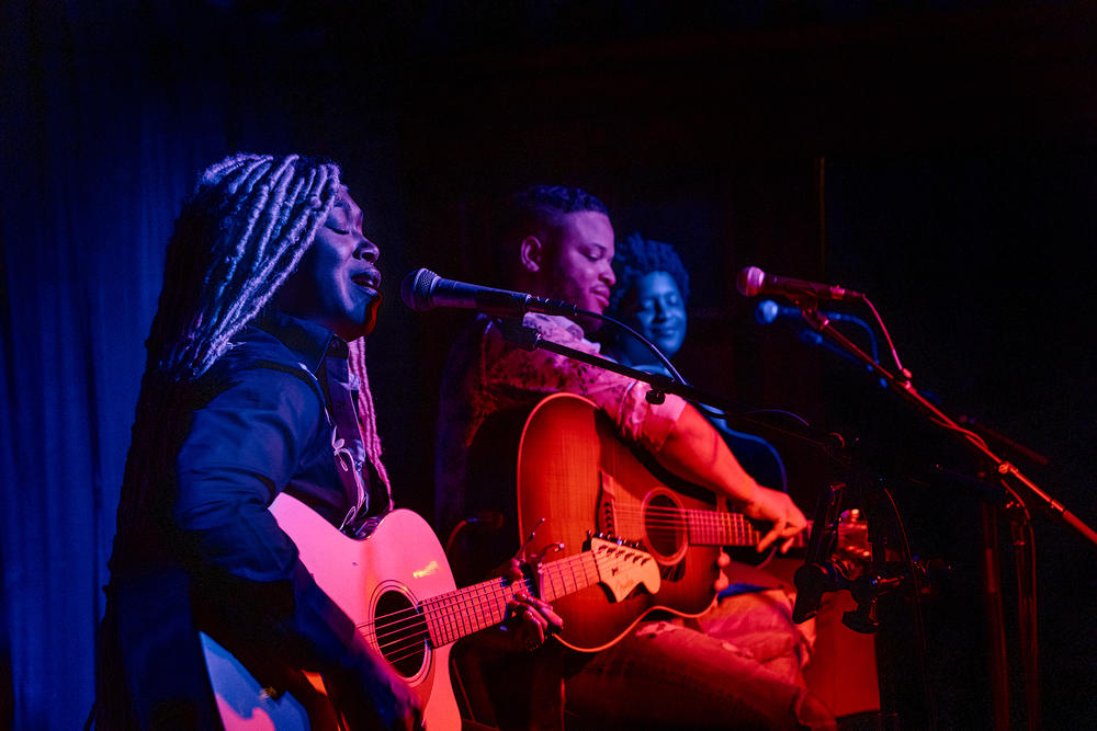 Larysa Jaye sings at Lulu's Downstairs while fellow artists, Tylar Bryant and Denitia listen in.