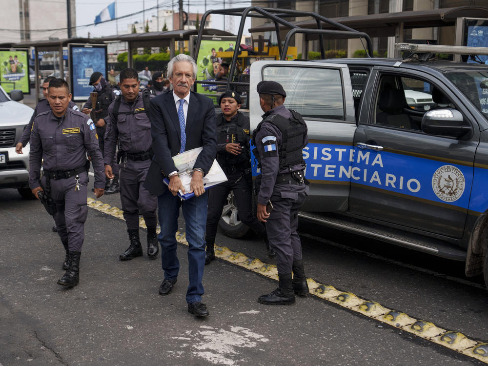 Police escort journalist José Rubén Zamora to court for a hearing related to his trial on alleged money laundering and other charges in Guatemala City, May 30. Zamora, founder and publisher of <em>El Periódico</em>, was convicted in June. He says the allegations are trumped up to silence an independent outlet that has been critical of governments for decades.