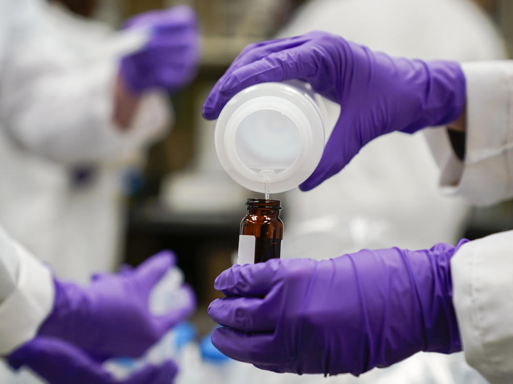 Eva Stebel, water researcher, pours a water sample into a smaller glass container for experimentation as part of drinking water and PFAS research at the U.S. Environmental Protection Agency Center For Environmental Solutions and Emergency Response on Feb. 16, 2023, in Cincinnati.