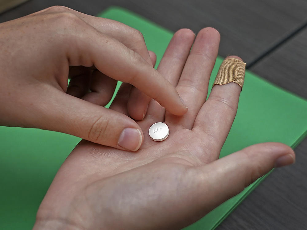 FILE - A patient prepares to take the first of two combination pills, mifepristone, for a medication abortion during a visit to a clinic in Kansas City, Kan., on Wednesday, Oct. 12, 2022.