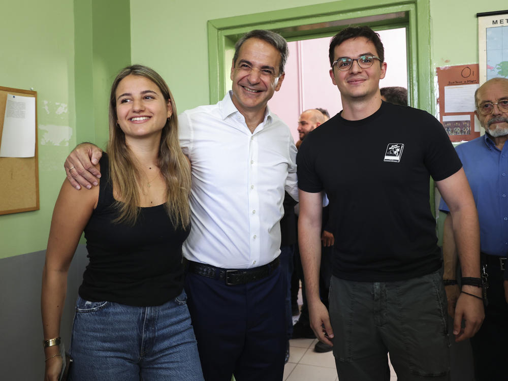 Kyriakos Mitsotakis, center, leader of center-right New Democracy party poses for the media with his daughter Dafni Mitsotakis, left, and son Konstantinos Mitsotakis at a polling station in Athens, Greece, on Sunday.