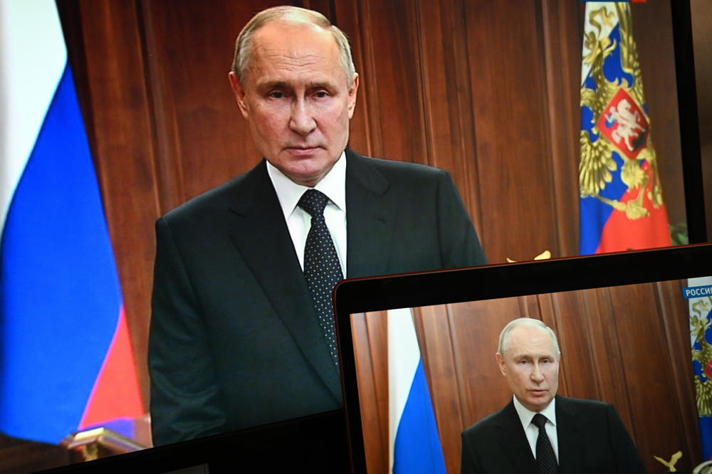 Russian President Vladimir Putin is seen on monitors as he addresses the nation on Saturday after Yevgeny Prigozhin, the owner of the Wagner Group military company, called for armed rebellion.