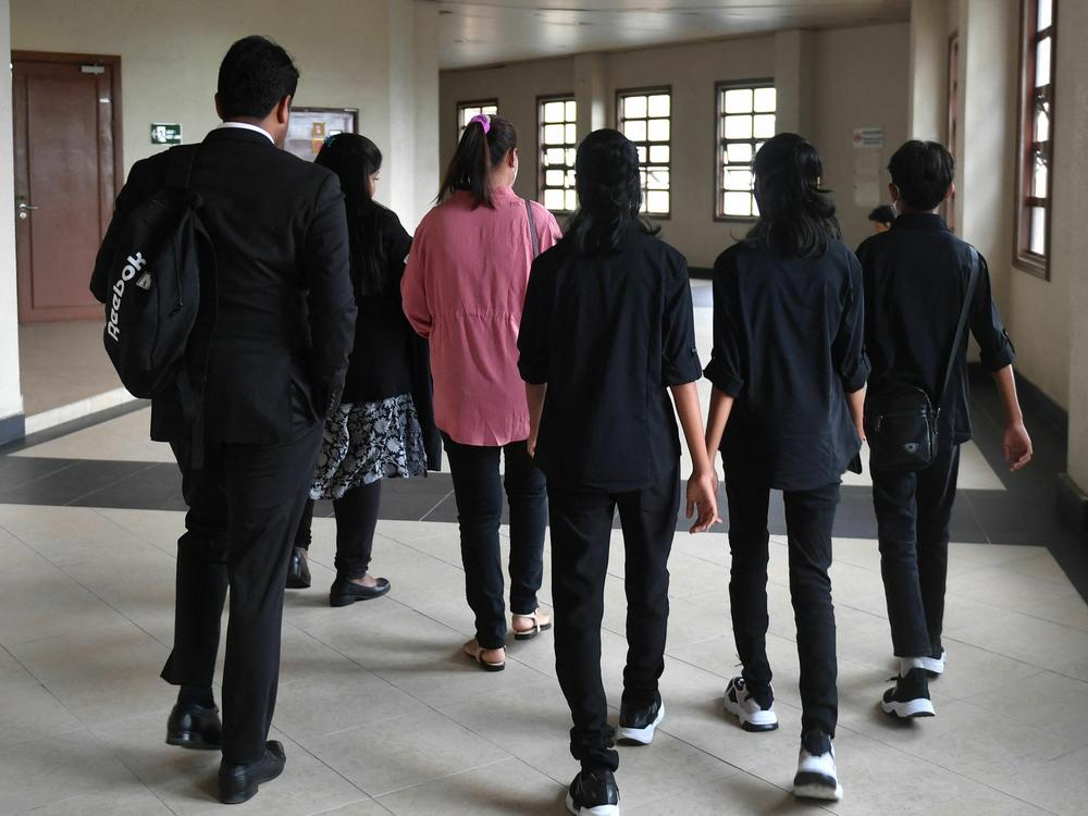 Loh Siew Hong, in a pink shirt, arrives with her three children at Kuala Lumpur High Court for a hearing on May 11.