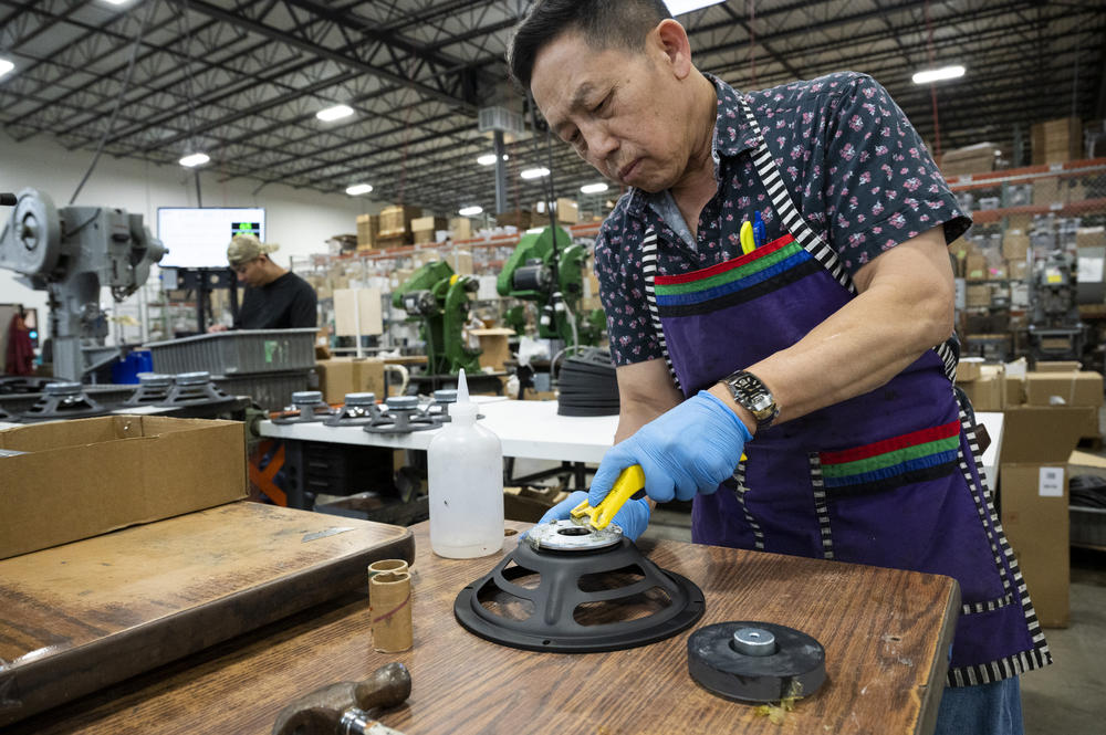 Louis Xiong assembles speaker baskets at the MISCO plant. Magnets are one of the few components of the speakers that the company has not regularly imported from China.