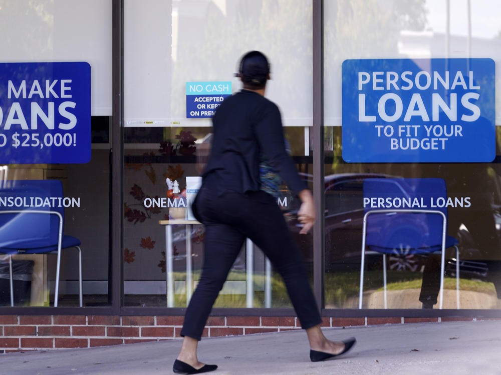 A woman walks past a personal finance loan office in October 2020 in Franklin, Tenn.
