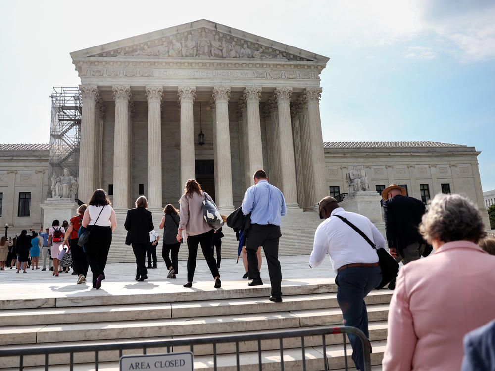People walk into the U.S. Supreme Court in Washington, D.C., on Tuesday, the day that the court's majority rejected the once-fringe idea that state legislatures' power over congressional elections cannot be checked or balanced by state constitutions or state courts.