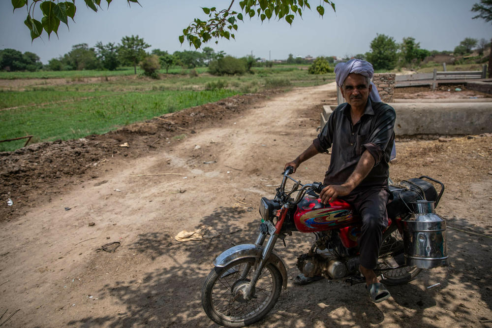 Javed Iqbal, whose brother Azmat Khan survived the shipwreck, rides his motorbike next to an area where he keeps his buffalo in Goleki village, Punjab province, Pakistan. Khan had sold his buffalo to pay for the voyage to Europe in the hope of landing a job so he could send money home to support his family.