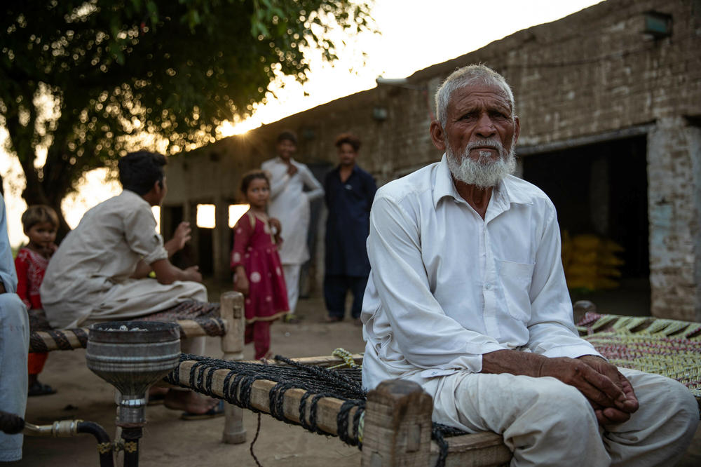 Muhammad Aslam, whose sons Qasim and Munir are still missing from the shipwreck, sits by his house in Noor Jamal village, Punjab province, Pakistan on June 22.