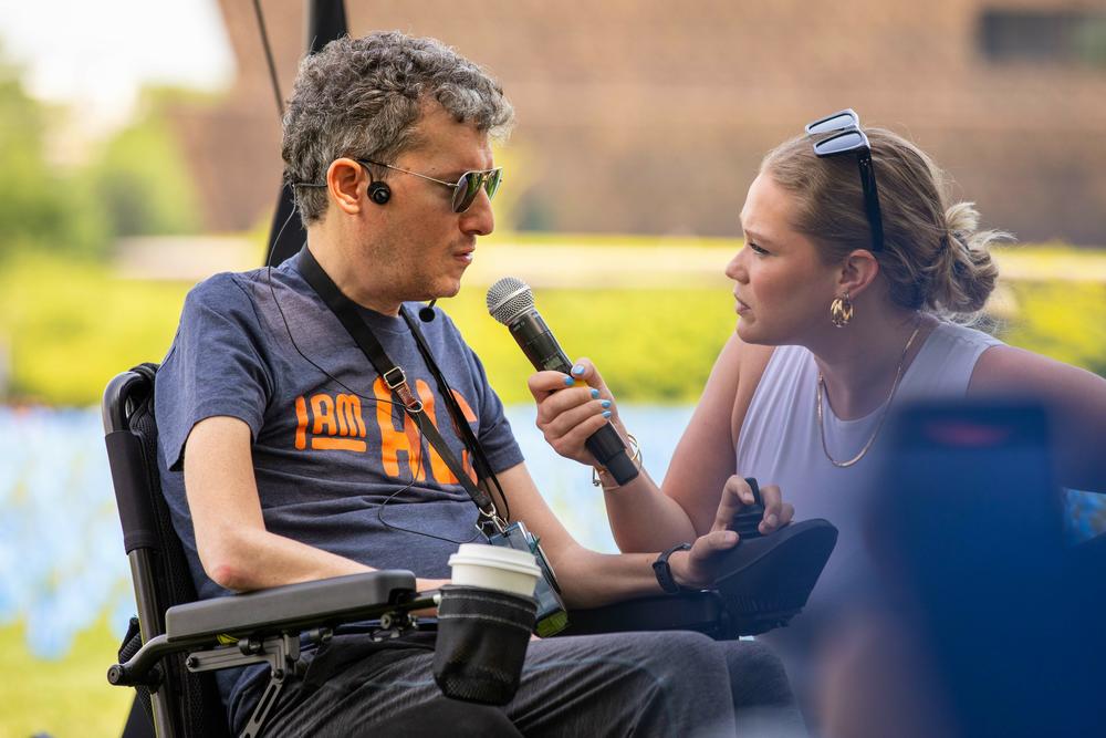 Wallach speaks at an I Am ALS event in Washington, D.C. with the help of his executive assistant Winona Koldyke.
