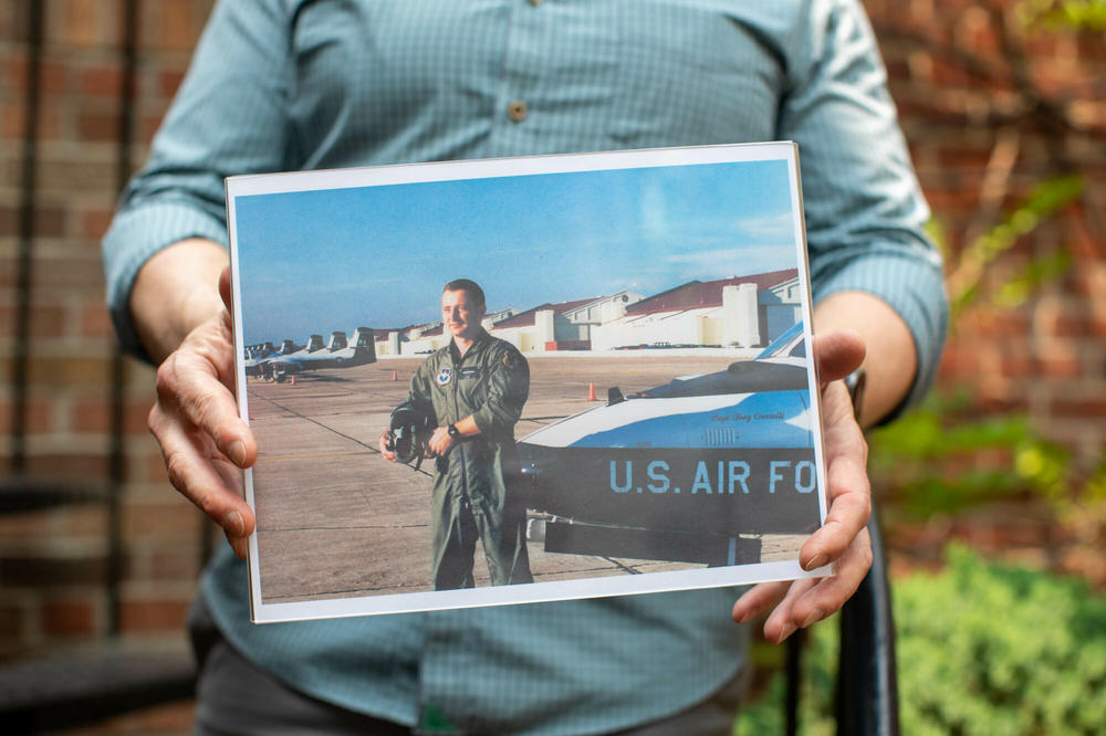 Bob Alexander, a retired lieutenant colonel in the U.S. Air Force, holds up a photo of when he was enlisted.