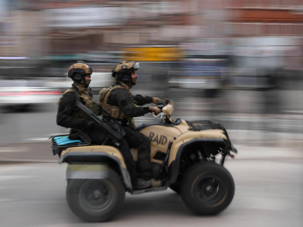 Officers from the RAID (Research, Assistance, Intervention, Deterrence) tactical unit of the French National Police patrol the street on a quad bike in Lille, northern France, on Friday.