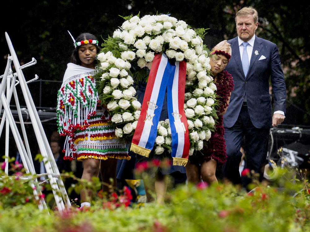 Dutch King Willem-Alexander lays a wreath at the slavery monument Saturday after apologizing for the royal house's role in slavery in a speech greeted by cheers and whoop.