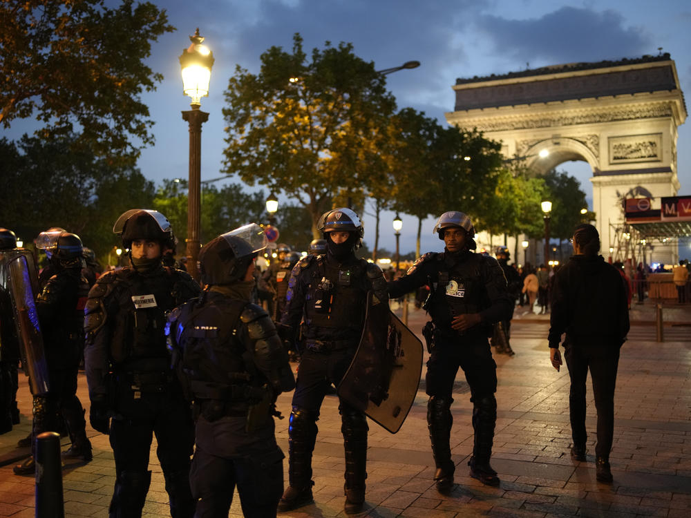 Police officers patrol in front of the Arc de Triomphe on the Champs Elysees in Paris on Saturday.