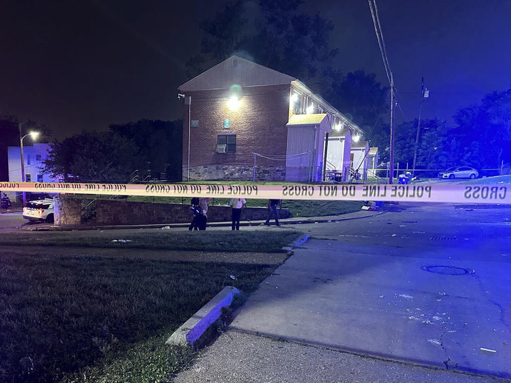 Police tape cordons off the area of a mass shooting in Baltimore early on Sunday. Police say a number of people were killed and dozens were wounded during a block party just after midnight.