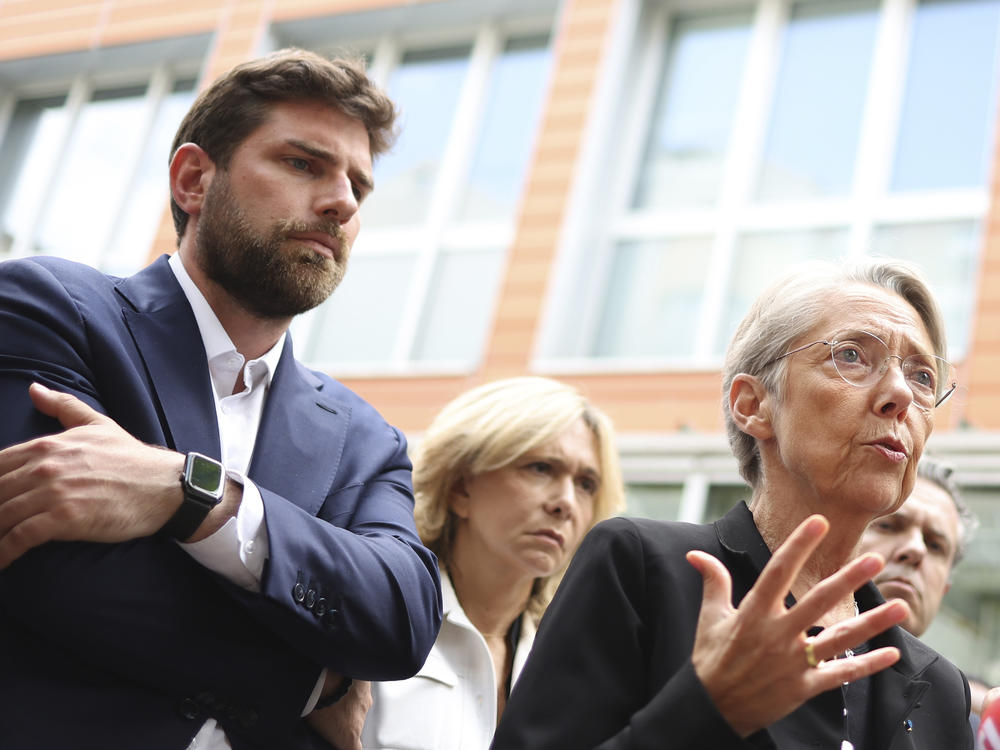 Vincent Jeanbrun, left, the Mayor of L'Hay-les-Roses, and French Prime Minister Elisabeth Borne talk to the media on Sunday after rioters rammed a vehicle into his house overnight.
