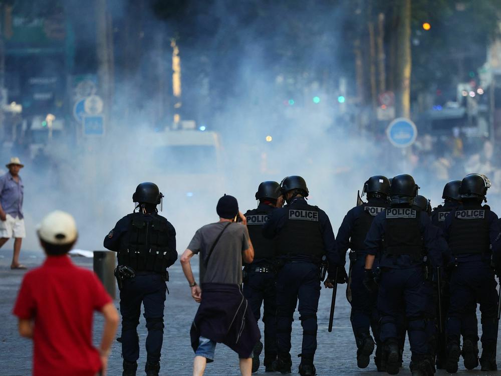 Police officers walk as they try to disperse protesters with tear gas during a demonstration against police in Marseille, southern France on July 1.