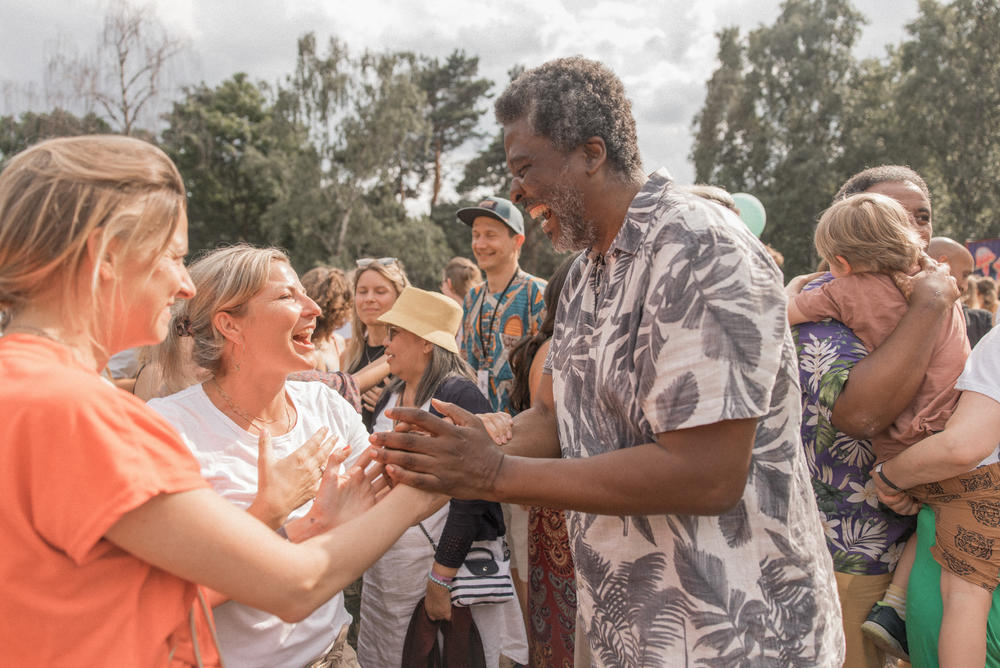 Edgard Gouveia believes in the power of games. He stages big communal games to help people connect and solve problems. Dancing together is part of his process. Above: A circle dance he staged at the PxP Festival in Berlin on June 18. After several minutes of dancing, he asked participants to hug at least 5 other people. Many of them came up to him to thank and hug him, too.